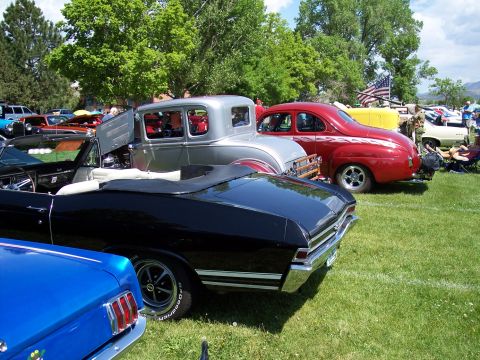 1972 Ford Ranchero - Several classic cars are parked on a grassy field under a partly cloudy sky.