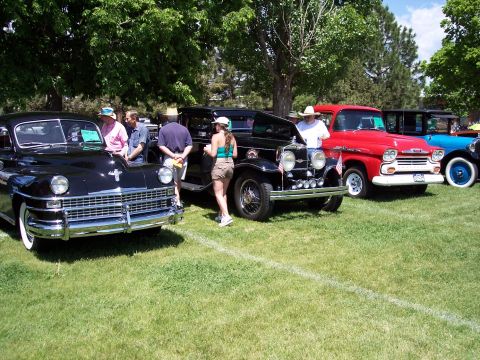 1972 Ford Ranchero - A variety of vintage vehicles are displayed on a grassy field under trees, with people milling around them.