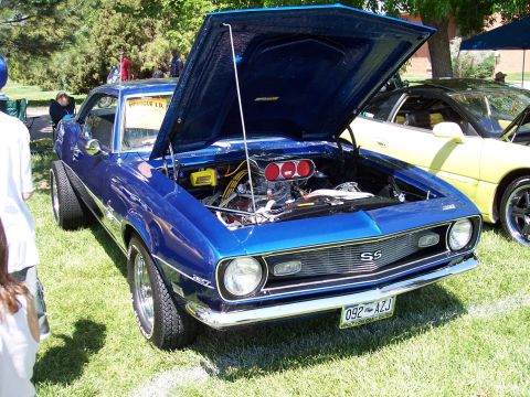 1972 Ford Ranchero - A blue 1969 Chevrolet Camaro SS is displayed with its hood open at an outdoor car show.