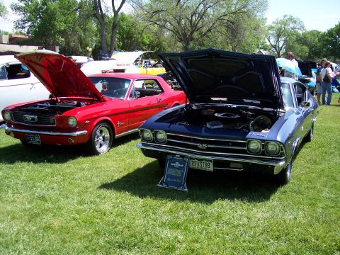 1972 Ford Ranchero - Two classic American muscle cars displayed with their hoods up at an outdoor car show.
