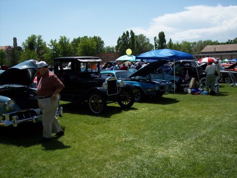 1972 Ford Ranchero - A sunny day car show features multiple vintage vehicles on display with attendees observing.