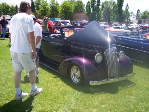 1972 Ford Ranchero - A vintage purple convertible is parked on the grass at a car show, with its hood open for display.
