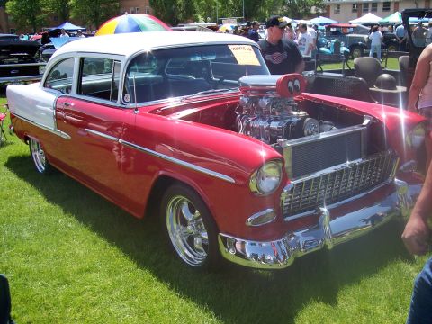 1972 Ford Ranchero - A red and white 1955 Chevrolet Bel Air with a prominent supercharger is displayed at a car show.
