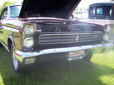 1972 Ford Ranchero - A maroon 1965 Mercury Comet Cyclone is displayed with its hood open at a car show.