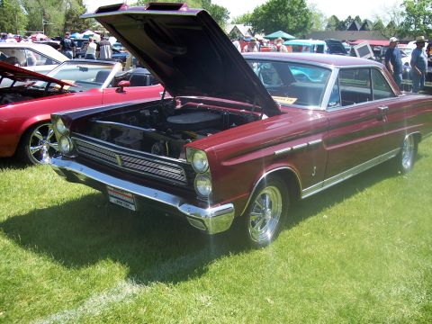 1972 Ford Ranchero - Maroon 1965 Mercury Comet displayed at a car show with its hood up.