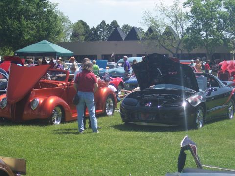 1972 Ford Ranchero - A black sports car is displayed with its hood open at an outdoor car show.