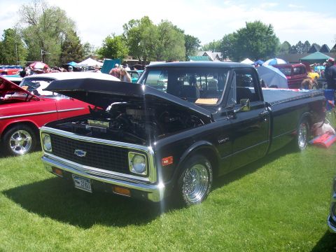 1972 Ford Ranchero - A black 1972 Chevrolet pickup truck is displayed with its hood open at an outdoor car show.