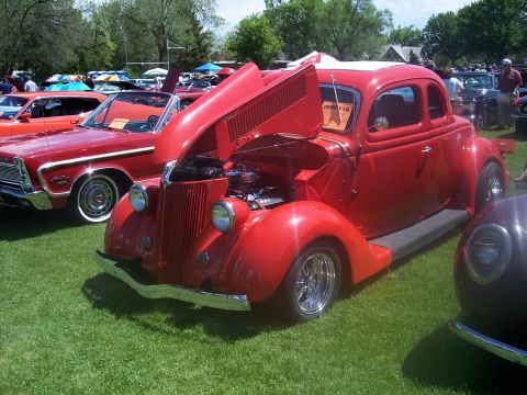 1972 Ford Ranchero - A red 1935 Ford coupe is displayed with its hood open at a car show, alongside other vehicles.