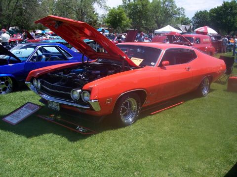 1972 Ford Ranchero - Orange 1970 Ford Ranchero at a car show, hood open, parked next to a blue vehicle.