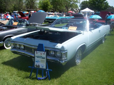 1972 Ford Ranchero - A light blue convertible is displayed at a car show with its hood open, next to other vehicles.