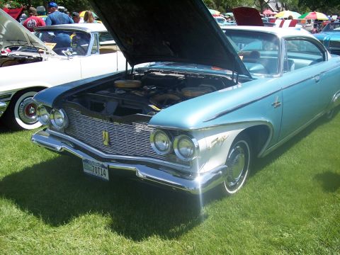 1972 Ford Ranchero - A light blue 1960 Dodge Dart is displayed with its hood open at a car show.