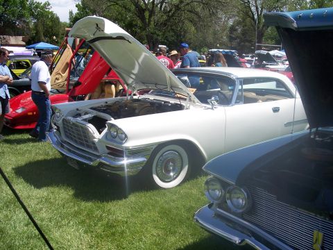 1972 Ford Ranchero - A white classic car is displayed with its hood open at an outdoor car show, with other vehicles and attendees in the background.