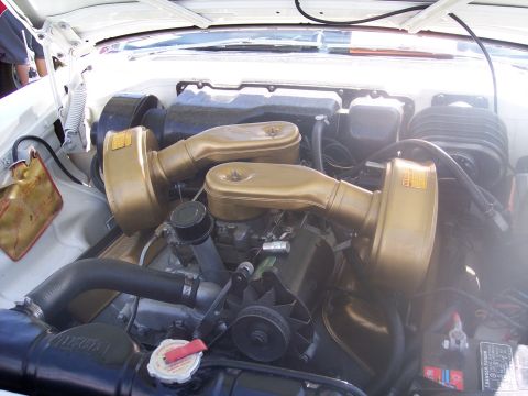 1972 Ford Ranchero - The engine bay of a vehicle is visible, dual gold air cleaners and a battery.