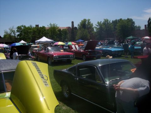 1972 Ford Ranchero - A 1965 Ford Mustang fastback is visible at a car show, surrounded by other classic vehicles and tents.