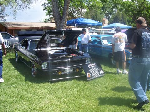 1972 Ford Ranchero - A black 1970 Plymouth Barracuda is displayed with its hood open at an outdoor car show.