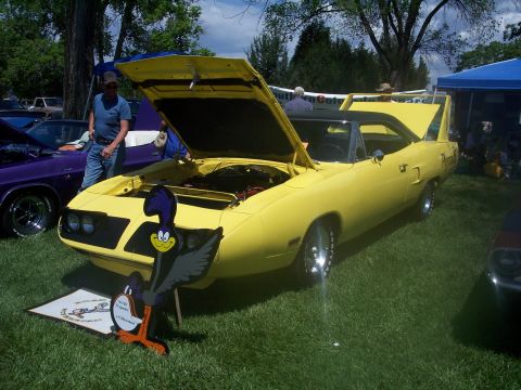 1972 Ford Ranchero - A yellow 1970 Plymouth Road Runner is displayed with its hood open at a car show.