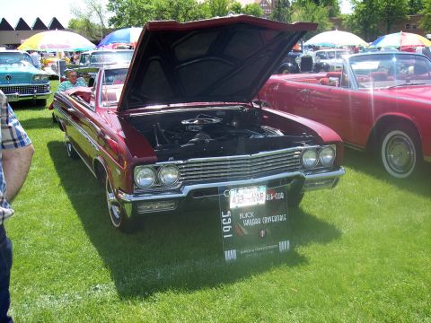 1972 Ford Ranchero - A red 1965 Buick Skylark convertible is displayed with its hood open at a car show.