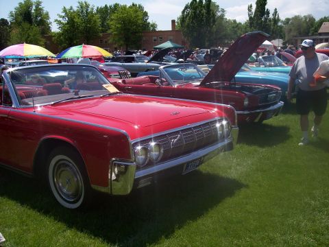1972 Ford Ranchero - A red 1965 Lincoln Continental convertible is displayed at a car show with other vehicles.