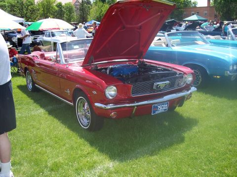1972 Ford Ranchero - A red convertible is displayed with its hood open at an outdoor car show, with another vehicle visible behind it.