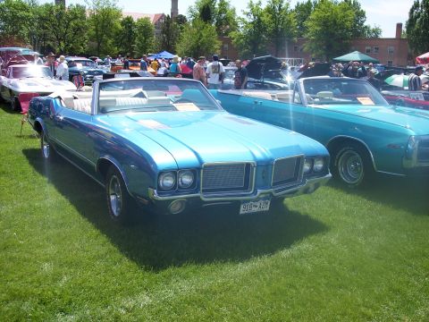 1972 Ford Ranchero - A blue convertible is displayed at an outdoor car show with other vehicles and people in the background.