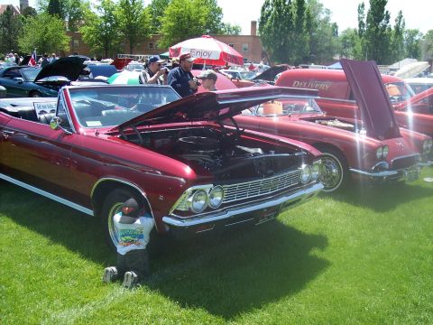 1972 Ford Ranchero - A red 1966 convertible is displayed with its hood open at a car show, alongside other vehicles.
