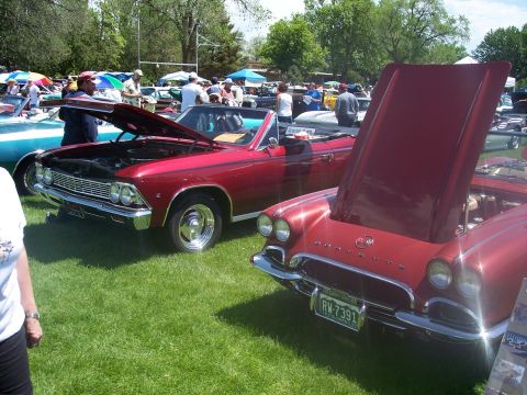 1972 Ford Ranchero - A red 1958 Chevrolet Corvette is parked next to another red convertible at a car show.