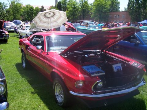 1972 Ford Ranchero - 1969 Ford Mustang on display at a car show, with other vehicles and people in the background.