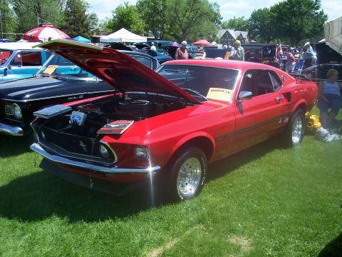 1972 Ford Ranchero - A red 1969 Ford Mustang Mach 1 is displayed at a car show with its hood open, alongside other vehicles.