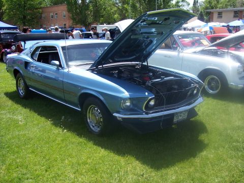 1972 Ford Ranchero - A blue 1969 Ford Mustang coupe is displayed with its hood open at an outdoor car show.