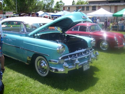 1972 Ford Ranchero - A classic aqua and white coupe is displayed with its hood open, parked on grass next to a red coupe at a car show.
