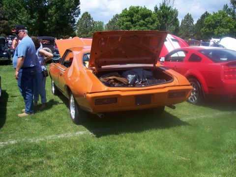 1972 Ford Ranchero - Rear view of an orange muscle car with its trunk open at an outdoor car show.