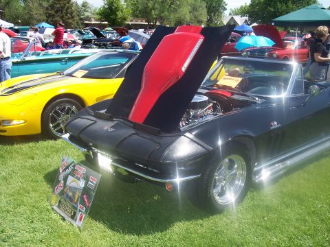 1972 Ford Ranchero - A black convertible sports car is displayed with its hood open at an outdoor car show, with other vehicles in the background.