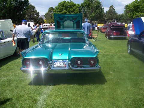 1972 Ford Ranchero - A teal 1959 Ford Thunderbird is displayed with its hood open at an outdoor car show.