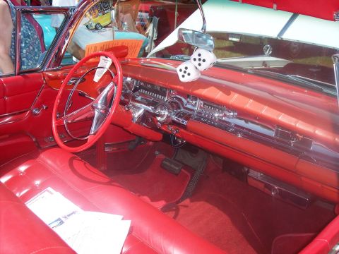 1972 Ford Ranchero - The interior of a classic red Cadillac Eldorado Brougham, complete with fuzzy dice, is on display at a car show.