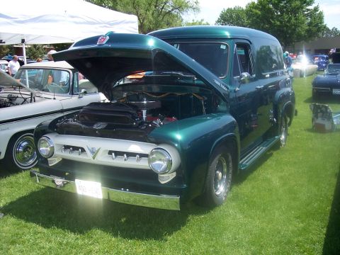 1972 Ford Ranchero - A green panel van with its hood open is displayed on a grassy field at a car show.