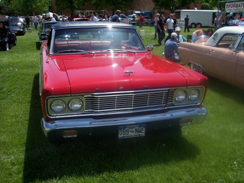 1972 Ford Ranchero - A red convertible is parked on a grassy field at an outdoor car show.
