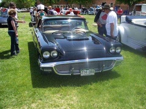 1972 Ford Ranchero - A black 1957 Ford Thunderbird is displayed at a car show, its distinctive front grille and headlights.