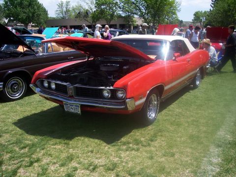 1972 Ford Ranchero - A red convertible is displayed at an outdoor car show with its hood up, revealing the engine compartment.