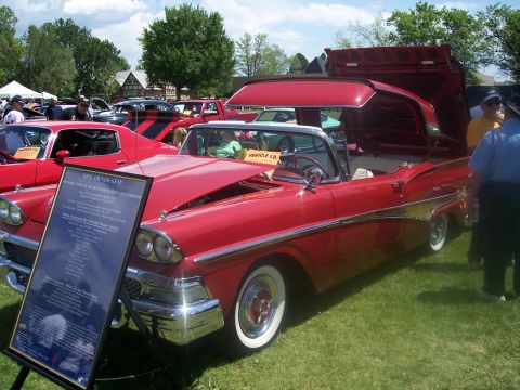 1972 Ford Ranchero - A red 1958 Ford Fairlane convertible is displayed at a car show with its hood open and a descriptive board next to it.