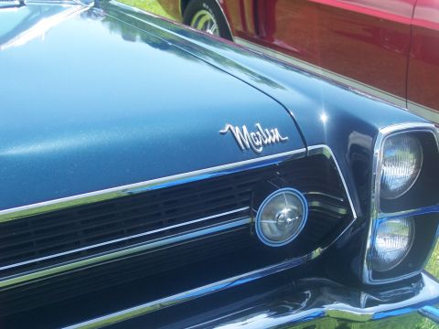 1972 Ford Ranchero - Front view of a blue car with a Marlin badge, parked next to a red vehicle.