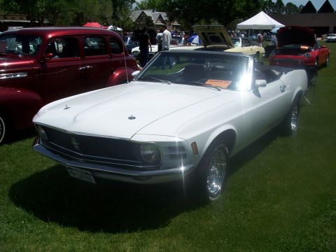 1972 Ford Ranchero - A white convertible is parked on the grass at a car show next to a maroon sedan.