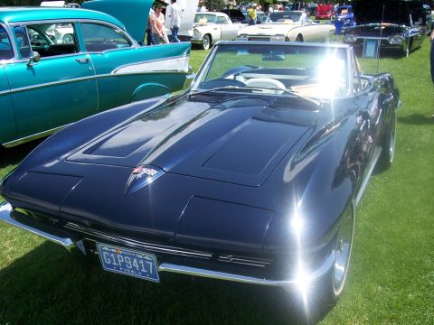 1972 Ford Ranchero - A dark blue convertible Corvette Sting Ray is parked on grass at a car show, with other classic cars visible.