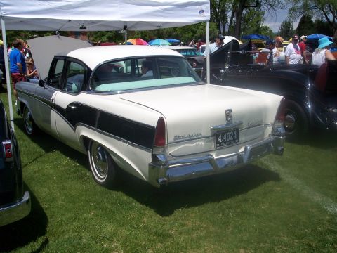 1972 Ford Ranchero - A two-tone 1956 Plymouth Belvedere sedan is displayed at a car show under a white tent.
