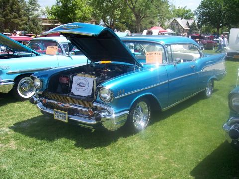1972 Ford Ranchero - A blue 1957 Chevrolet Bel Air is displayed at a car show, its hood open to reveal the engine.