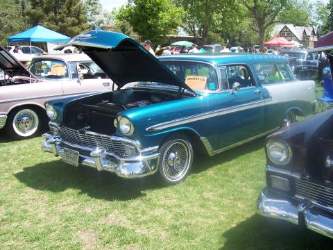 1972 Ford Ranchero - A teal and white 1956 Chevrolet Nomad station wagon is displayed with its hood open at an outdoor car show.