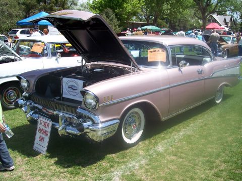 1972 Ford Ranchero - A pink 1957 Chevrolet Bel Air is displayed with its hood open at a car show.