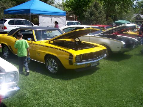 1972 Ford Ranchero - A yellow 1969 Chevrolet Camaro SS is displayed with its hood open at a car show.