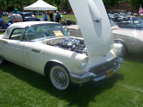 1972 Ford Ranchero - A white 1957 Ford Thunderbird is displayed with its hood open at a car show, showing off its engine and wire wheels.