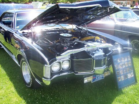 1972 Ford Ranchero - Black 1971 Oldsmobile Cutlass Supreme on display at a car show, engine compartment open.