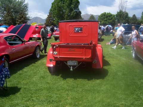 1972 Ford Ranchero - A red Ford pickup truck is parked on grass at an outdoor car show.